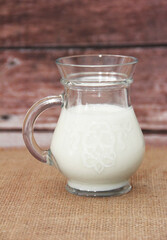 white fermented milk drink ayran in a transparent glass mug in the form of a jug