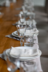 Festive romantic table setting with silverware, gray napkin and white crockery on beige silk tablecloth