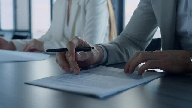 Hand holding pen checking document closeup. Employee reading contract details