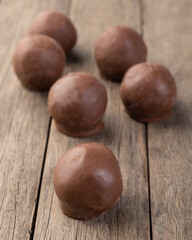 Filled chocolate candy with candies over wooden board