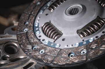 Close-up clutch disc of a car lies on metal parts contrast shot