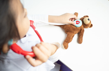 children role play as doctor with teddy bear