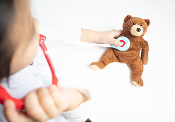 children role play as doctor with teddy bear