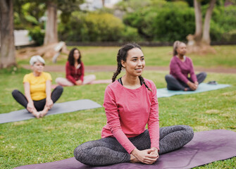 Group of diverse women doing yoga exercise at city park
