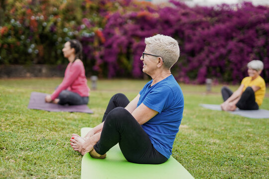 Multi generational women having fun during yoga exercise lesson outdoor