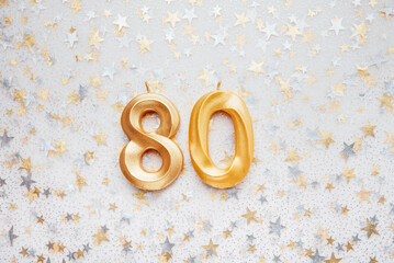 Number 80 eighty golden celebration birthday candle on Festive Background. eighty years birthday. concept of celebrating birthday, anniversary, important date, holiday