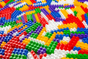 Abstract background texture of colored constructor blocks. Background of colorful plastic part of constructor. Pile of colored toy bricks.