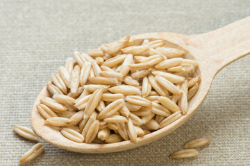 Wooden spoon with oats. Cooking oatmeal. Diet food.