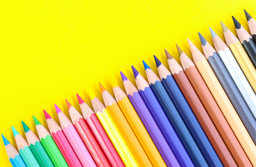 colored pencils with copy space on yellow background educational concept