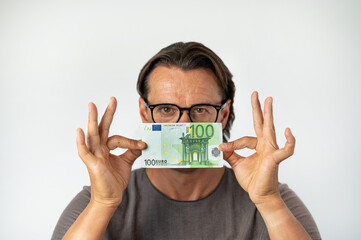 Middle aged man holding money in front of his face