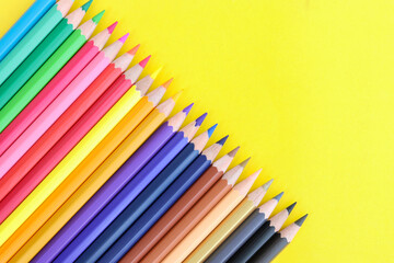 colored pencils with copy space on yellow background educational concept