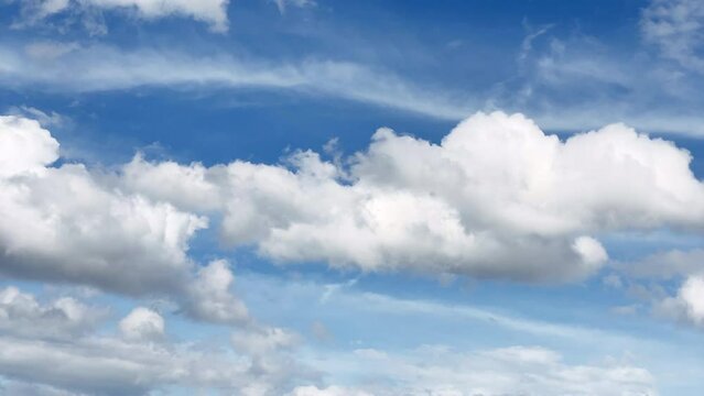 Time-lapse footage of flowing and drifting white clouds in the blue sky.  Cumulus and cirrus cloud. Cloudscape. Japan.