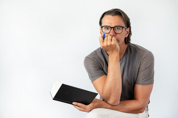 Mature educated man wearing glasses and reading a book