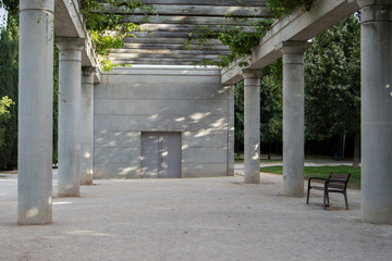 Concrete pergola with wooden bench in the linear park of Manzanares in Madrid. Spain