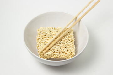 Dry instant noodles in a plate on a white background. Fast food. Modern food.