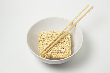 Dry instant noodles in a plate on a white background. Fast food. Modern food.