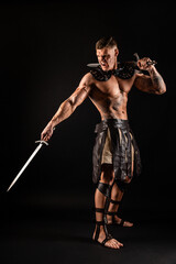 Antique warrior with sword against dark background