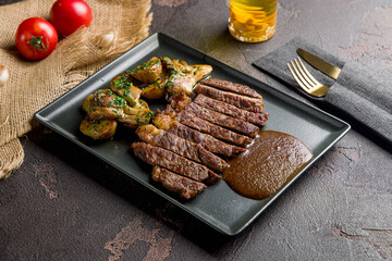 Beef steak sliced with potatoes and pepper sauce on plate
