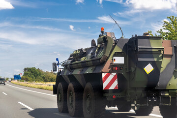 Close-up German armoured personnel carrier fuchs drive military convoy highway road. ALLIANCE...