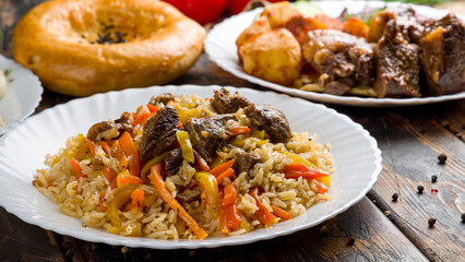 pilaf with beef and kazan kebab on wooden table macro close up