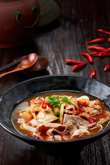 Closeup of Chinese pork offal rice noodles on dark wooden table