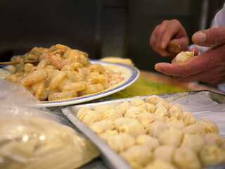Close up local chef hand making raw shrimp wontons, dumpling, traditional style, famous local hong kong chinese cantonese food, selective focus