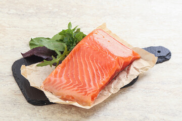 Raw salmon fillet over board