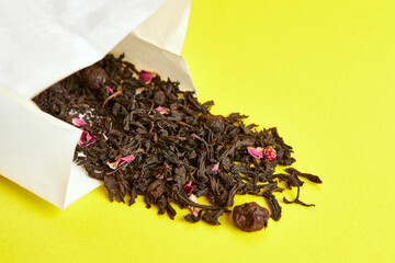 Paper bag with fruit tea on a yellow background.