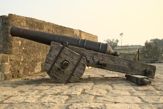 Side view of a movable sixteenth century Portuguese cannon made of metal and a wooden base. It's located on a bastion of Diu Fort, Diu, India