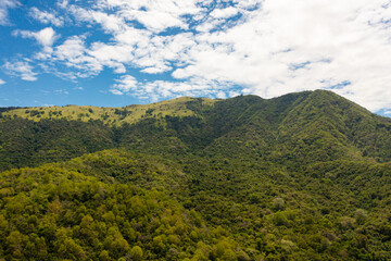 Top view of Mountains with green forest a background of blue sky and clouds. Sri Lanka.