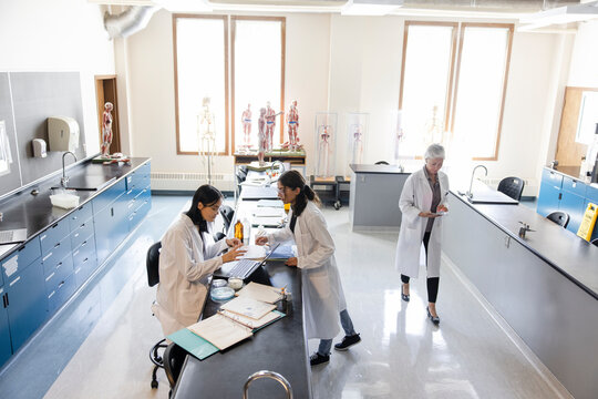 Female college students conducting scientific experiment in lab