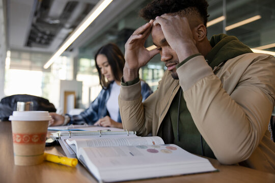 Focused Young Male College Student Studying In Library