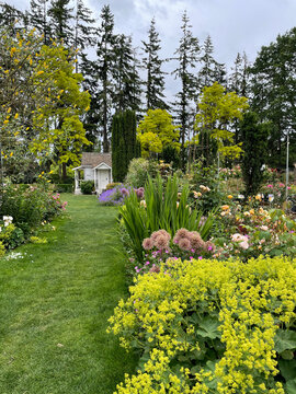 Landscaped yard with a white cottage at the end of the path