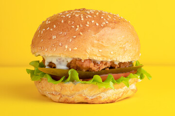 Burger with chicken, on a yellow background, bright background