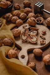 Wooden board with open half walnuts on a wooden table. Walnut peeling process. Natural protein for healthy nutrition.