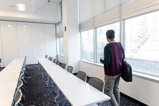 Male College Professor Entering Empty Classroom