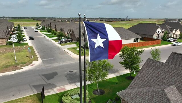 Population growth in State of Texas. Flags fly over residential housing sprawl in suburbs of TX USA. Homes and houses in neighborhood community.