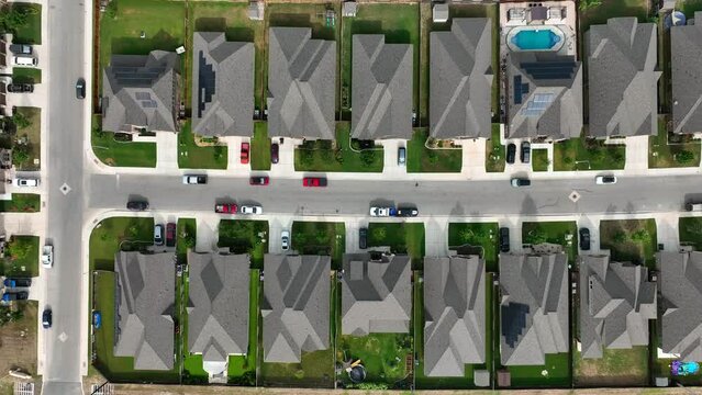 Top down aerial view of houses packed together in new residential neighborhood in American suburb. Urban sprawl and population growth theme.