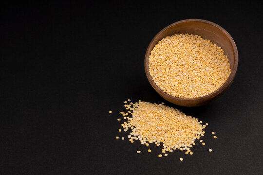 peeled split mung bean isolated in rock bowl on black background.