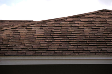 Closeup of house roof top covered with asphalt or bitumen shingles. Waterproofing of new building