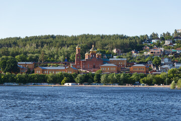 The concept of Catholic holidays. The monastery at sunset. A beautiful monastery on an island in the middle of a lake. The monastery stands on a hill surrounded by a forest.