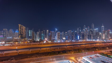 Fototapeta na wymiar Panorama of Dubai marina tallest block of skyscrapers night timelapse.
