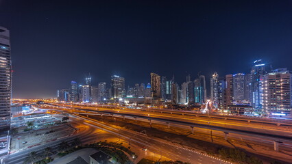 Fototapeta na wymiar Dubai Marina skyscrapers and Sheikh Zayed road with metro railway aerial night timelapse, United Arab Emirates