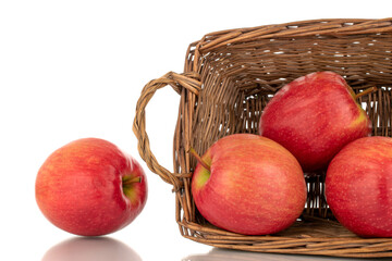 Four juicy red apples with a basket, close-up, isolated on a white background.