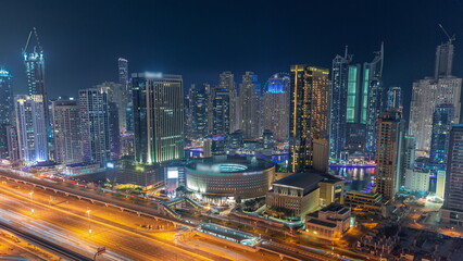 Obraz na płótnie Canvas Dubai Marina skyscrapers and Sheikh Zayed road with metro railway aerial night timelapse, United Arab Emirates