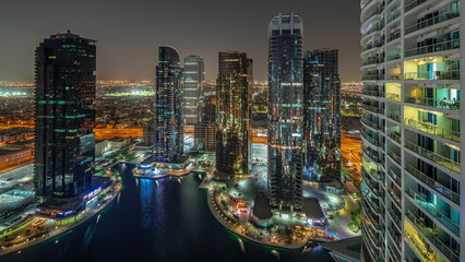 Tall residential buildings at JLT aerial night timelapse, part of the Dubai multi commodities centre mixed-use district.