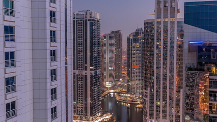 Fototapeta premium Tall residential buildings at JLT aerial day to night timelapse, part of the Dubai multi commodities centre mixed-use district.