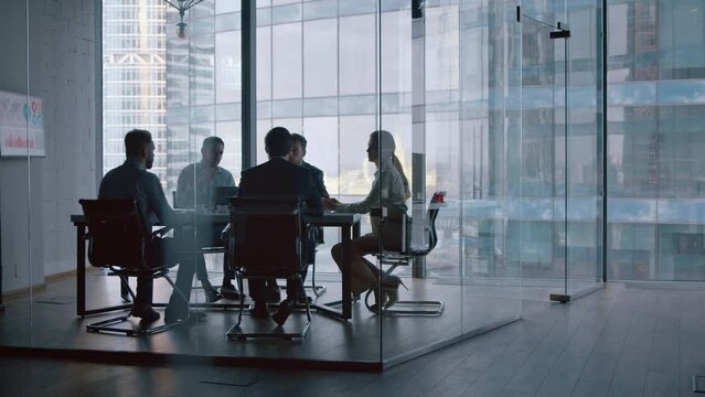 Business partners shaking hands after a completed deal in boardroom