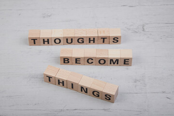 wooden cubes showing the words thoughts become things