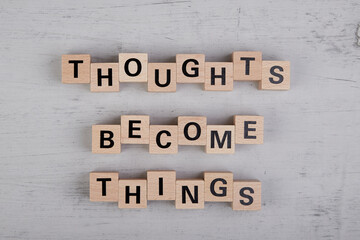 wooden cubes showing the words thoughts become things